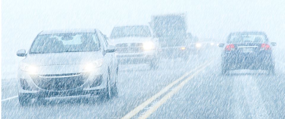 Cars driving on a motorway during heavy snow and bad weather