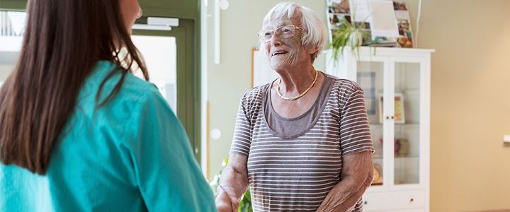 A care worker visits a resident in a care home