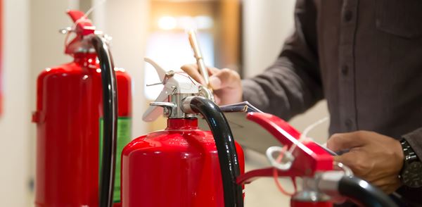 Health and safety employee checks fire extinguishers in case of a fire