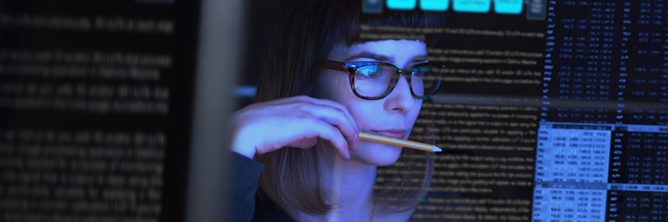woman studying a see through computer screen & contemplating Intellectual property insurance.