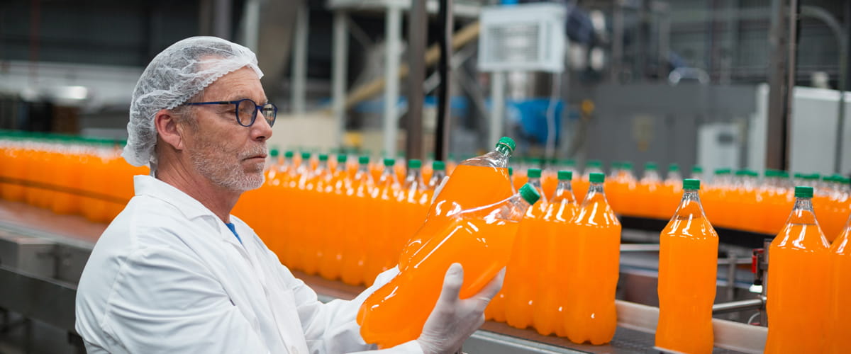 Production line worker inspecting a bottle
