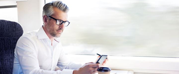 Businessman on train looking at phone