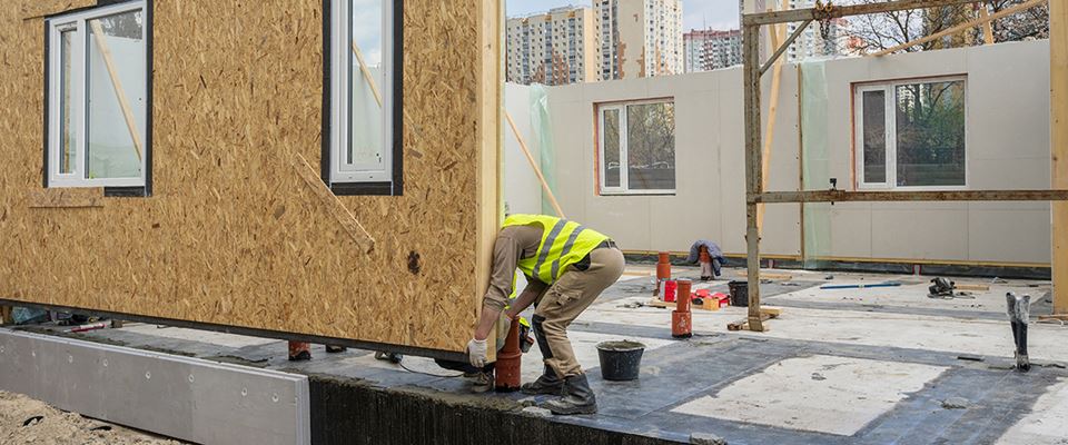 Construction worker slotting in the side panel of a building