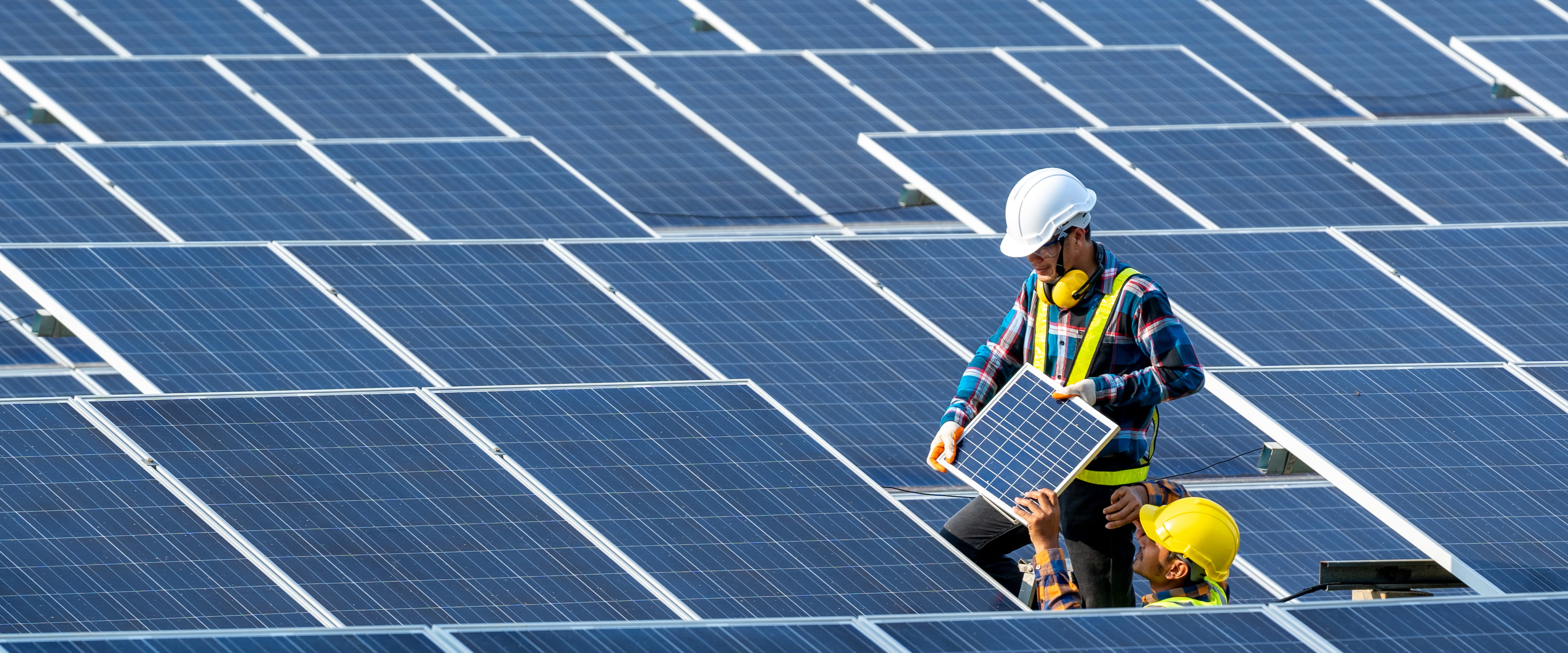 Engineer laying down solar panels to produce renewable energy