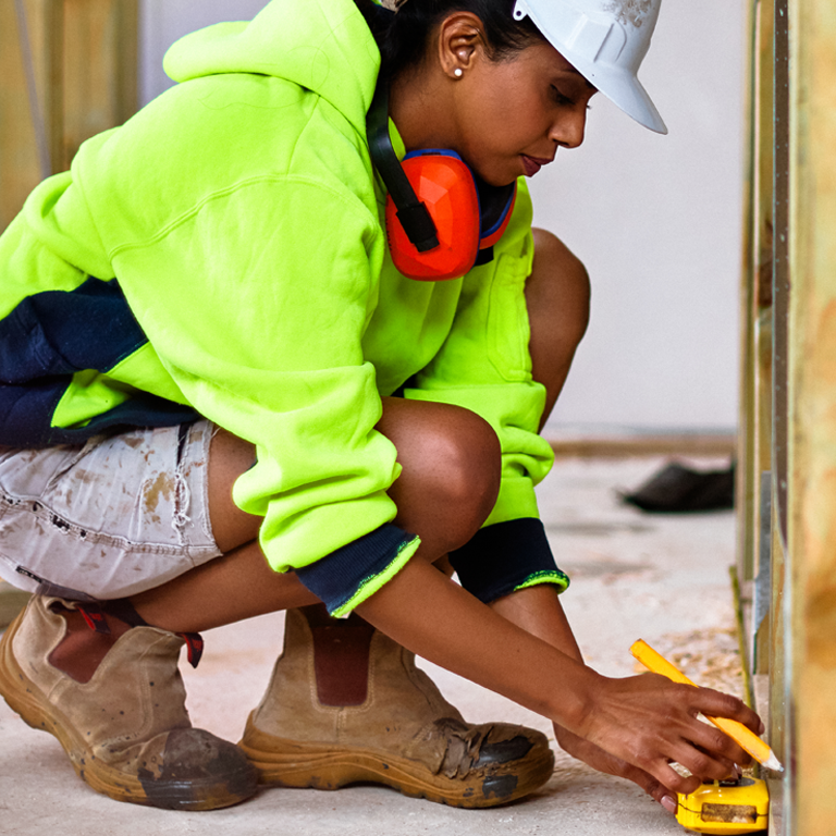 Female worker using tape measure at site