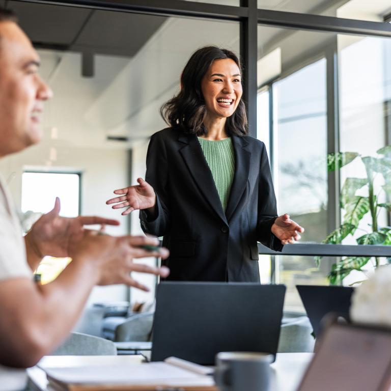 Woman presenting to colleagues in a modern office meeting about claims inflation and risk trends.