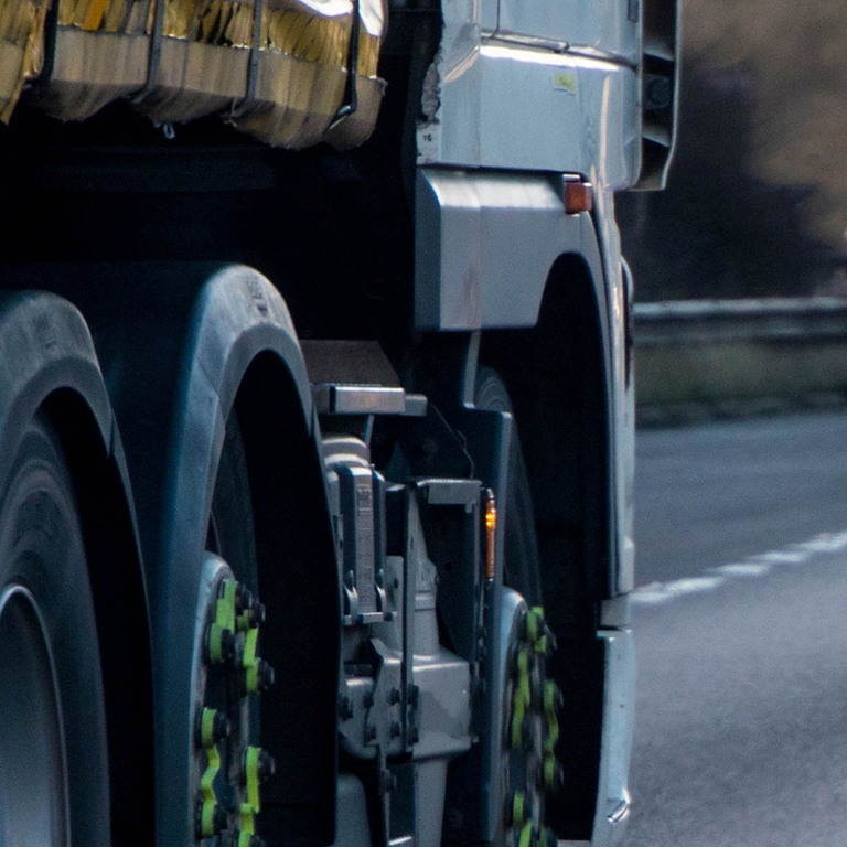 Close-up of a truck's rear wheels on a winding road, highlighting the importance of addressing retail supply chain challenges.