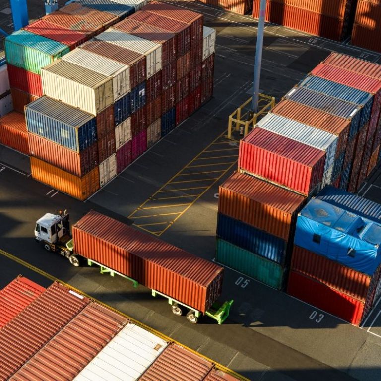 Trucks move containers in busy shipping yard